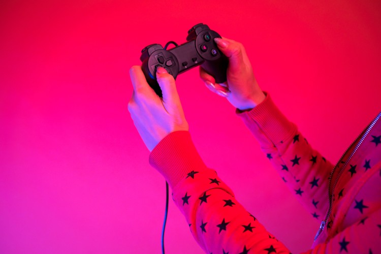 gamepad-in-female-hands-on-a-colored-background-