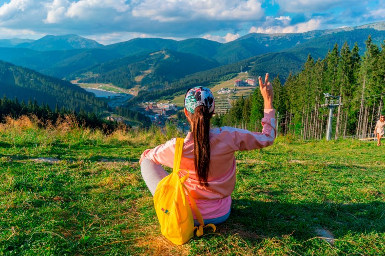 woman-with-yellow-backpack-enjoys-mountain-view