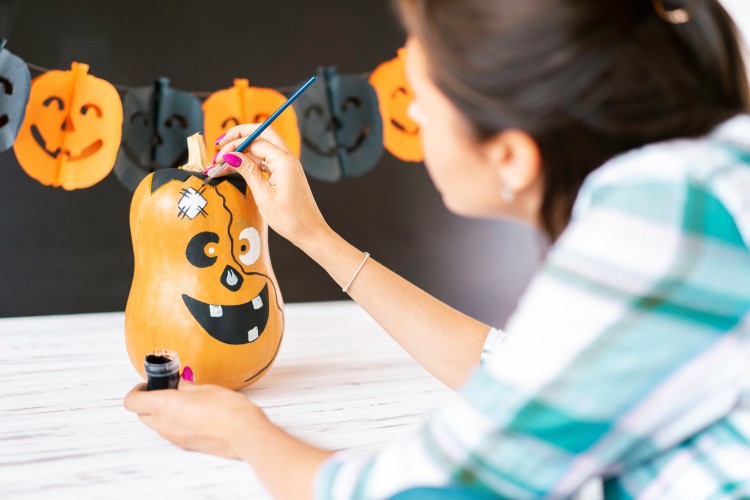 woman-decorates-halloween-pumpkin