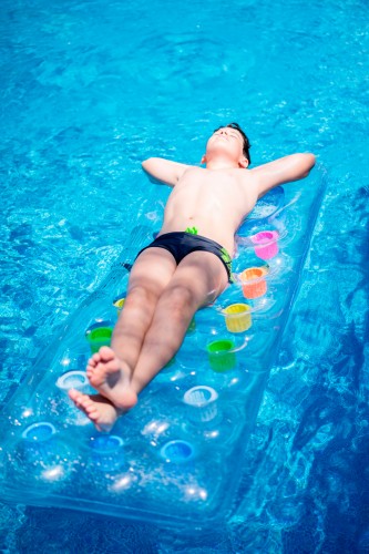 boy-on-the-swimming-mattress-in-the-swimming-pool