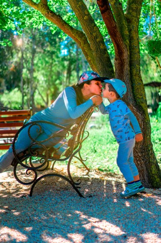 kid-kissing-mother-in-the-park