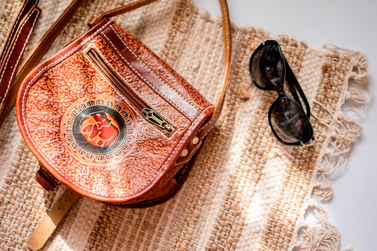 leather-purse-and-sunglasses-on-the-decorative-carpet