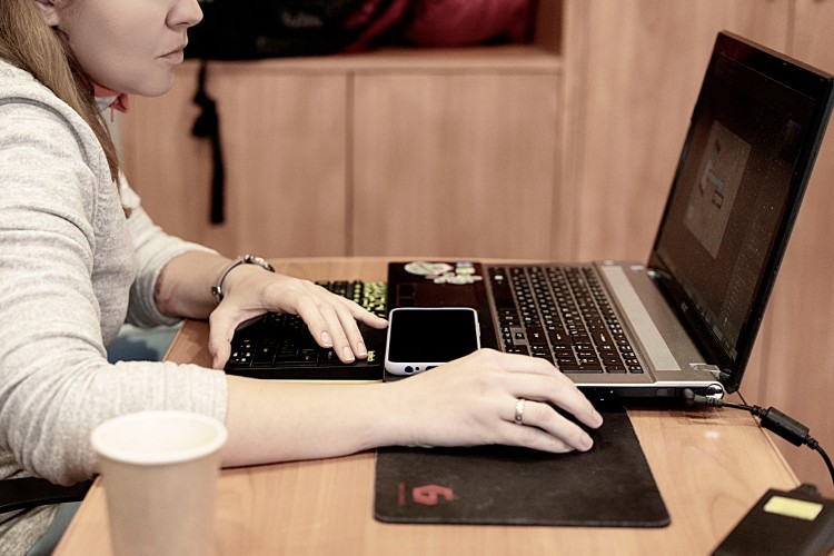 side-view-of-a-woman-working-with-laptop-in-the-cafe