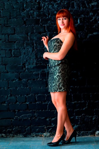 gorgeous-woman-in-dress-standing-near-the-black-wall