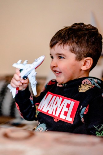 smiling-kid-playing-with-toy-plane