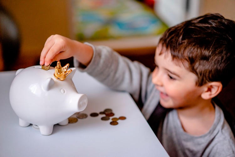cute-little-boy-putting-coin-in-the-piggybank