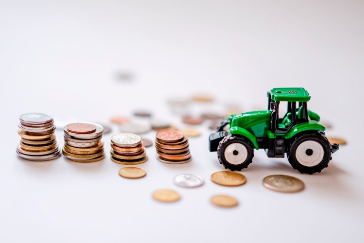 toy-tractor-and-coins-on-a-white-surface