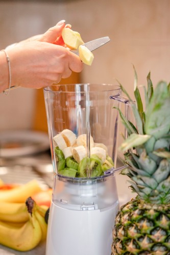 woman-cuts-fruits-for-the-smoothie