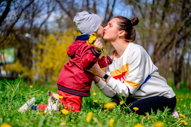 woman-kisses-her-little-son-on-a-spring-day