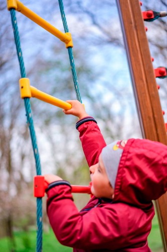 little-boy-in-red-windbreaker-on-the-rope-ladder