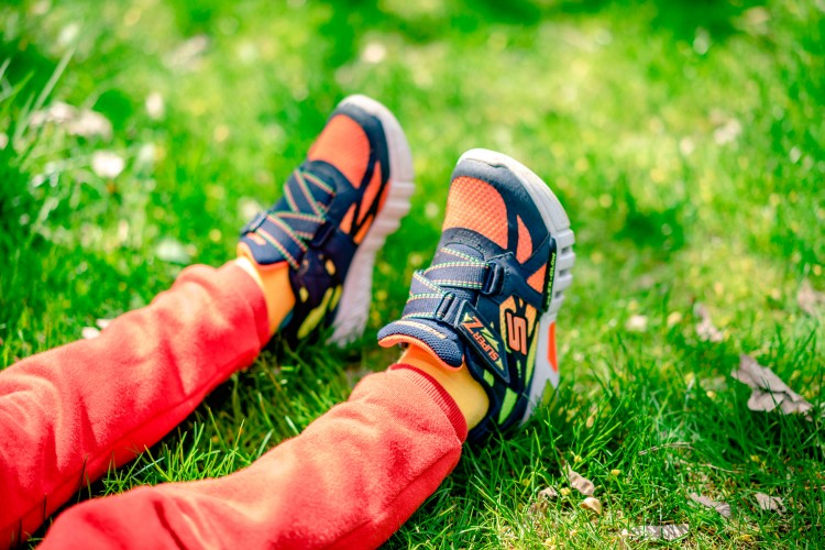 kids-legs-in-bright-sneakers-on-the-grass