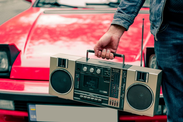 man-with-retro-boombox-near-the-red-car