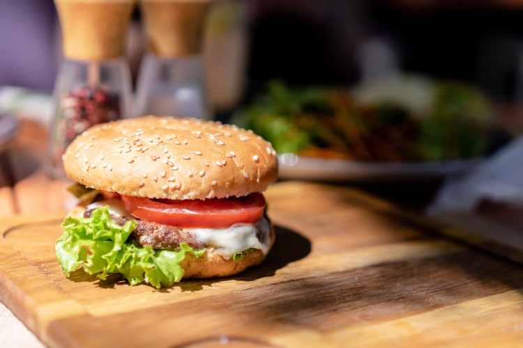 hamburger-on-a-wooden-plate-in-a-cafe