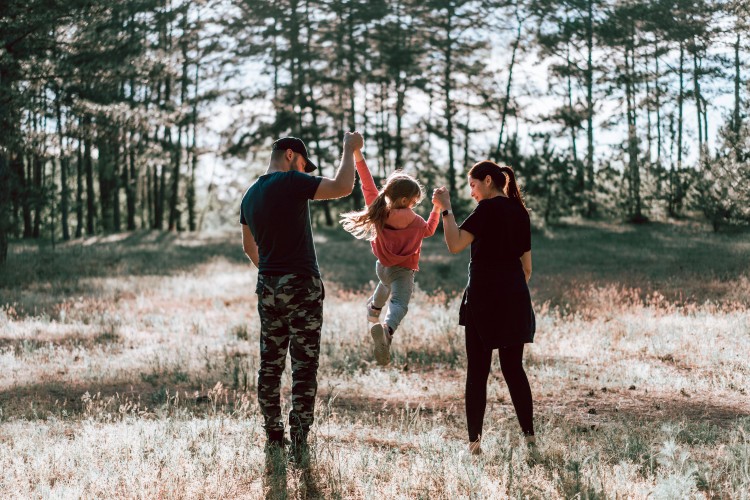 family-holding-hands-in-the-forest
