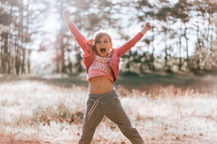 excited-little-girl-jumping-on-nature-background