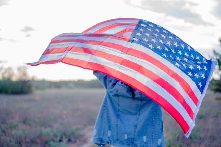 woman-in-denim-jacket-holding-american-flag