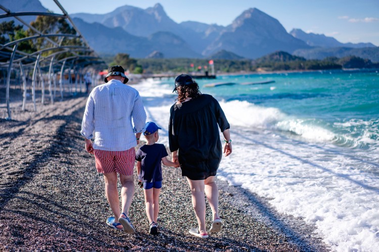 family-walk-down-the-pebble-sea-beach