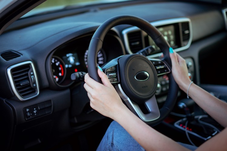 female-hands-hold-the-steering-wheel-of-the-car