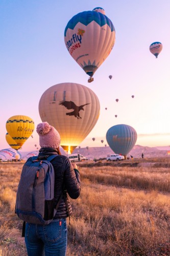 the-girl-looks-at-the-balloons-of-cappadocia