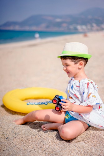 smiling-kid-in-summer-hat-at-the-sandy-beach