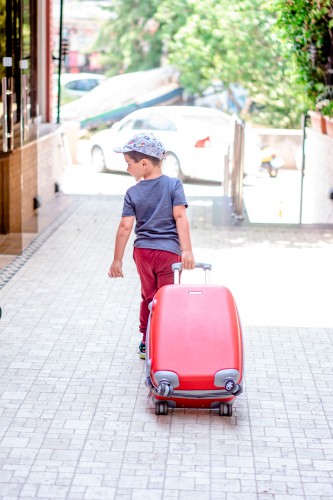 kid-with-travel-suitcase-on-the-street