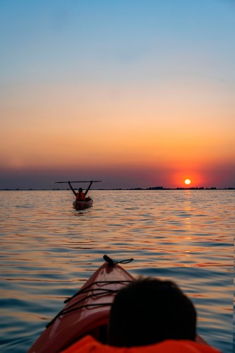people-on-kayaks-on-the-sunset-background