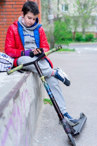 teenager-with-smartphone-and-electric-scooter