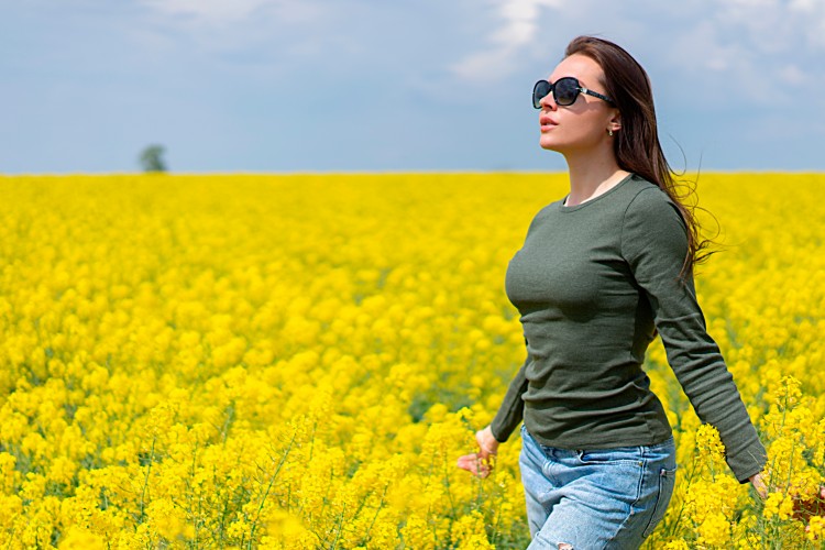 young-brunette-woman-in-a-blooming-yellow-field