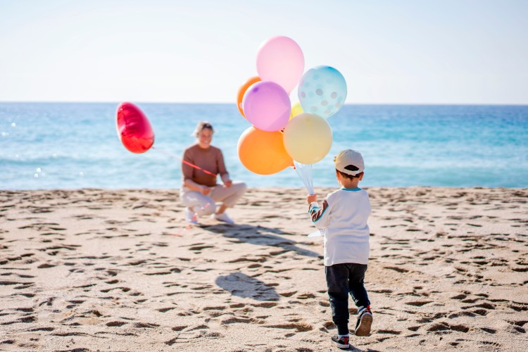 woman-and-kid-with-party-balloons-at-the-beach