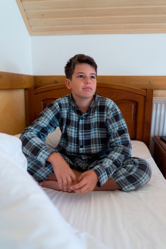 boy-in-checkered-pajama-sitting-on-the-bed