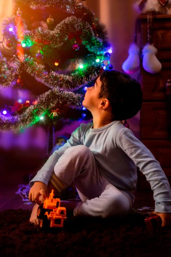 boy-playing-near-christmas-tree