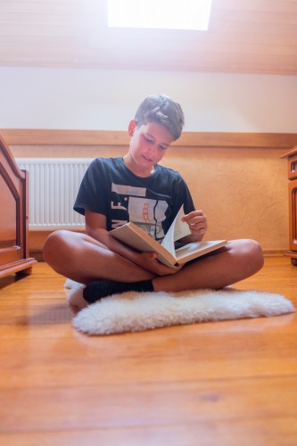 boy-with-a-book-sitting-on-the-carpet