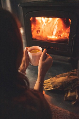 girl-with-a-cup-of-tea-by-the-fireplace