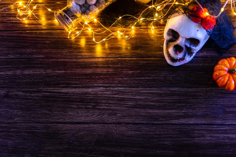 halloween-composition-with-skull-and-lights-on-wooden-background