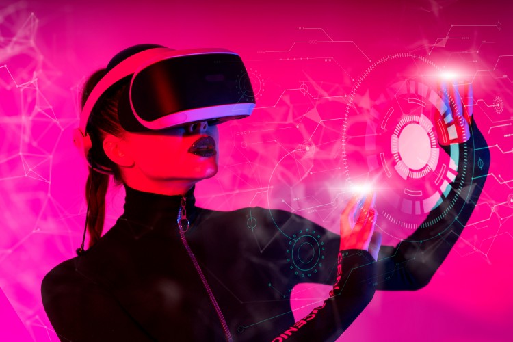 young-woman-using-glasses-of-virtual-reality-on-pink-background