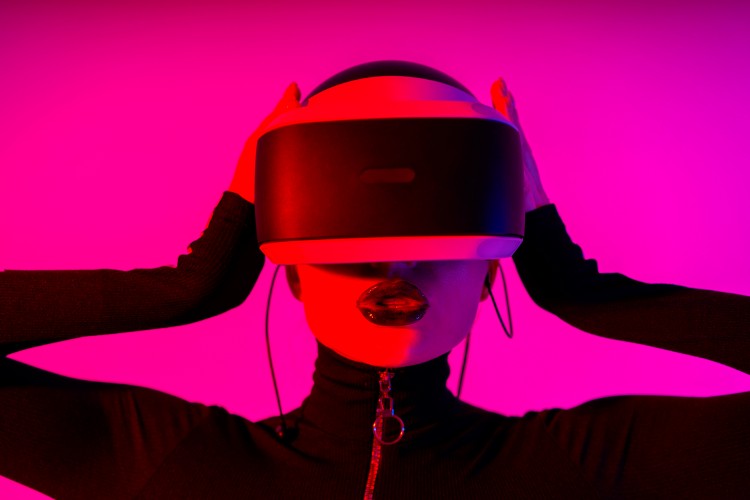 young-woman-in-vr-headset-posing-on-pink-background