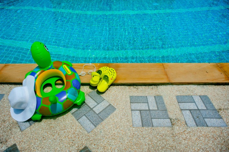 summer-composition-with-swim-ring-hat-and-crocs-at-the-pool