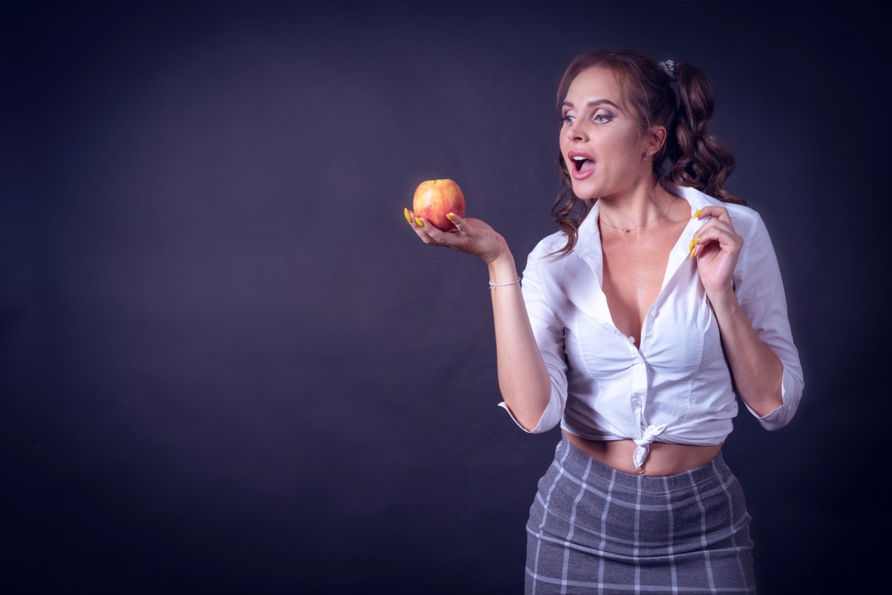 Sexy student girl holding apple