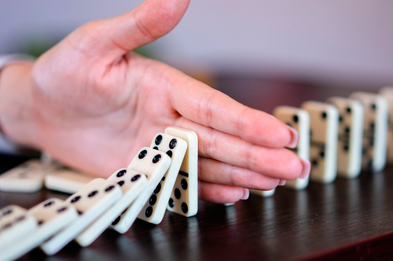 Hand with dominoes on the table