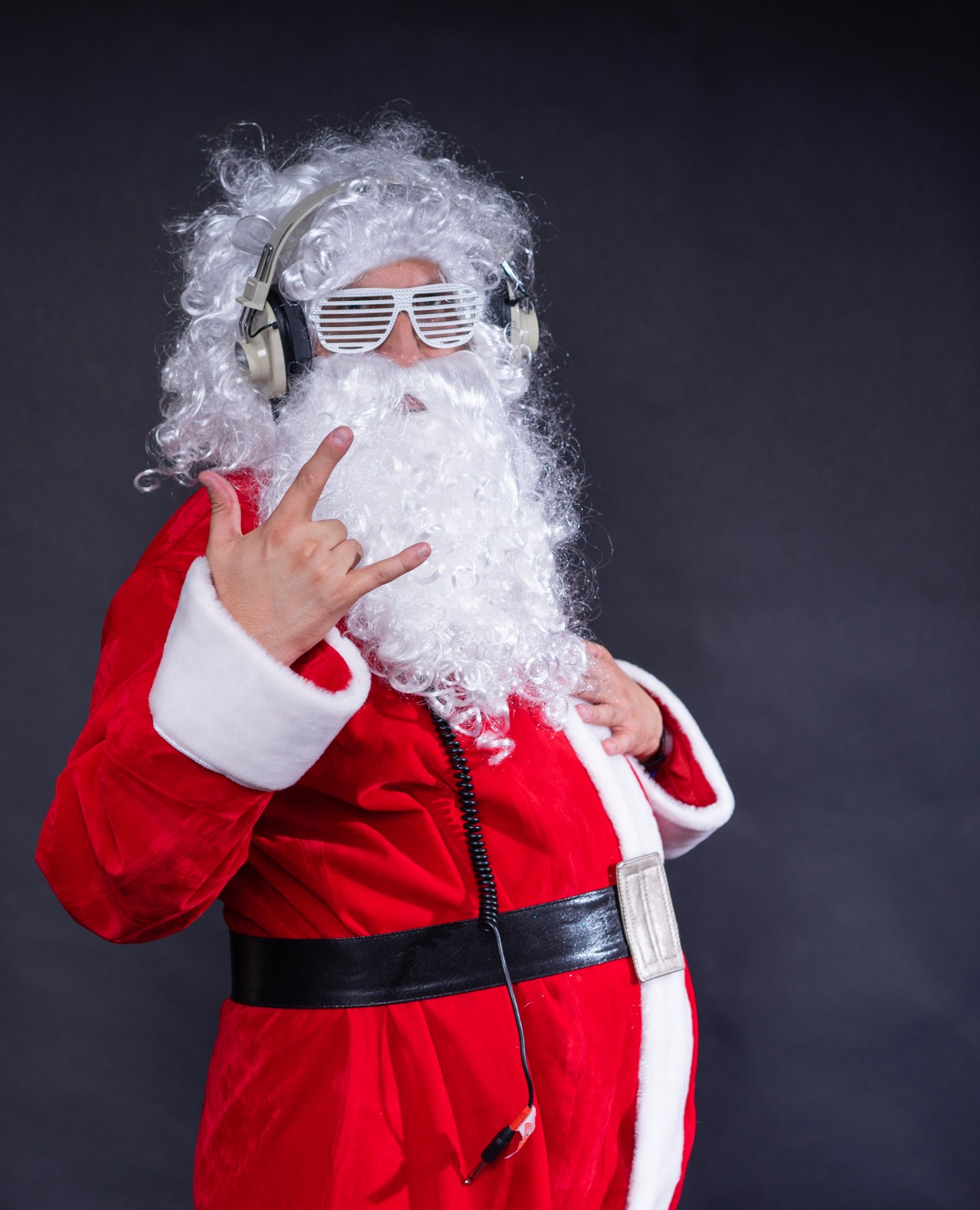 Santa Claus in headphones shows rock gesture