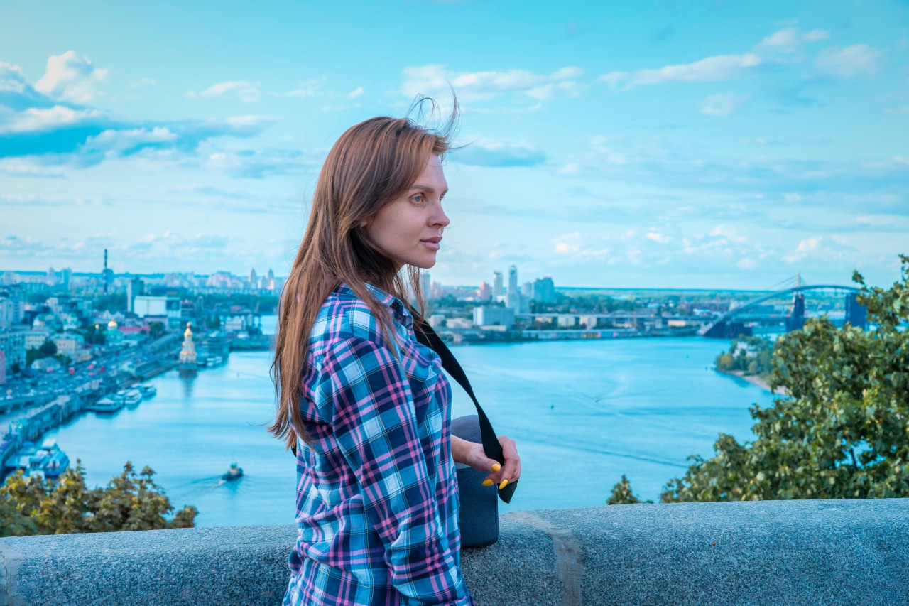 Dreamy woman standing on the blurred city background