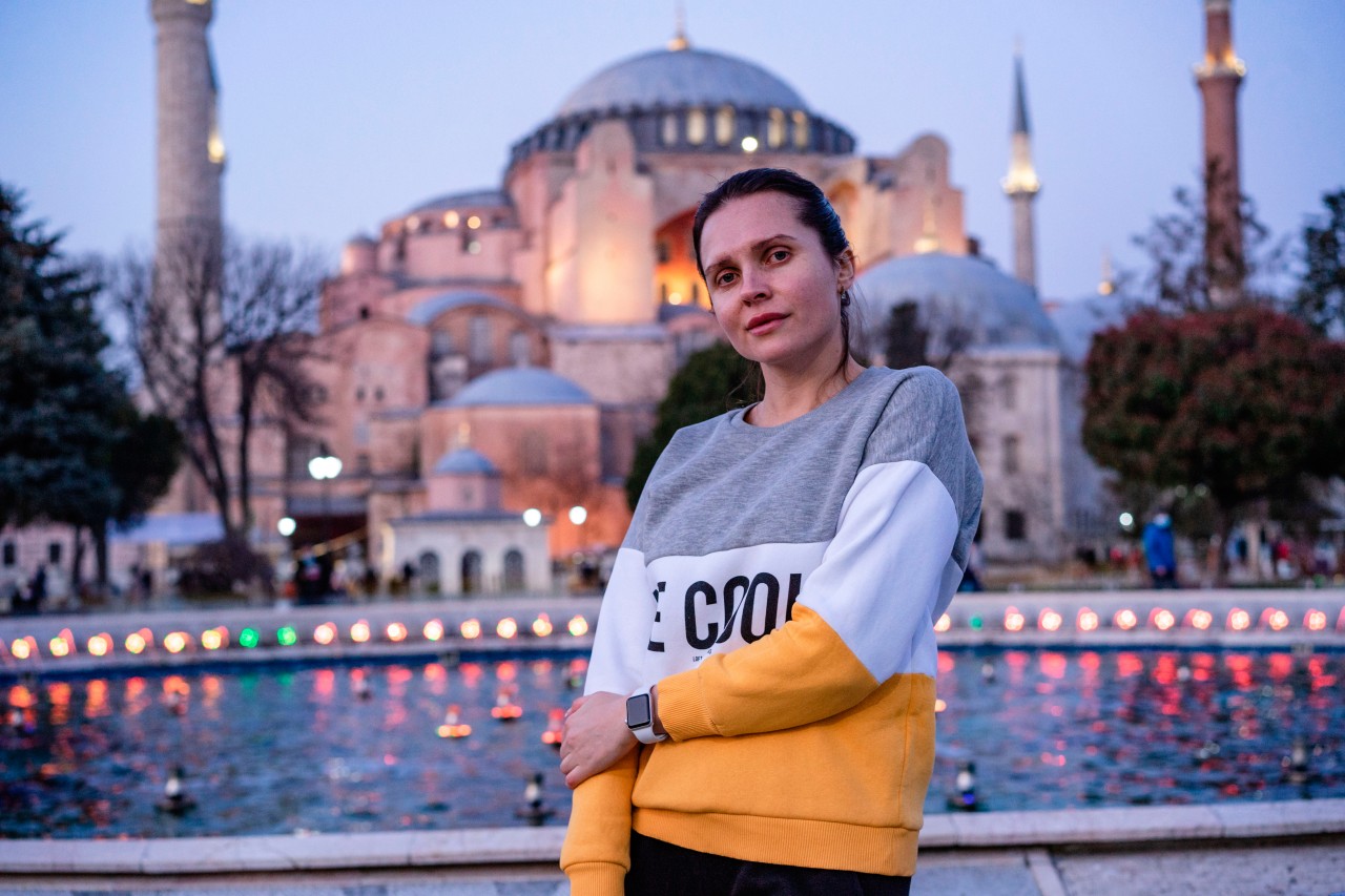 Woman in sweatshirt in front of the mosque in Turkey