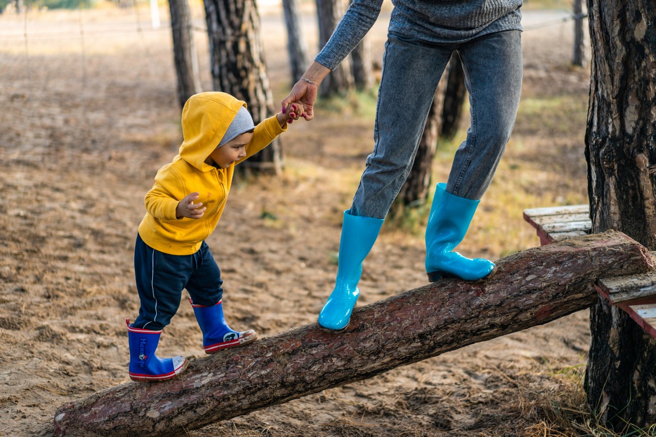 Woman and kid in rubber shoes holding hands