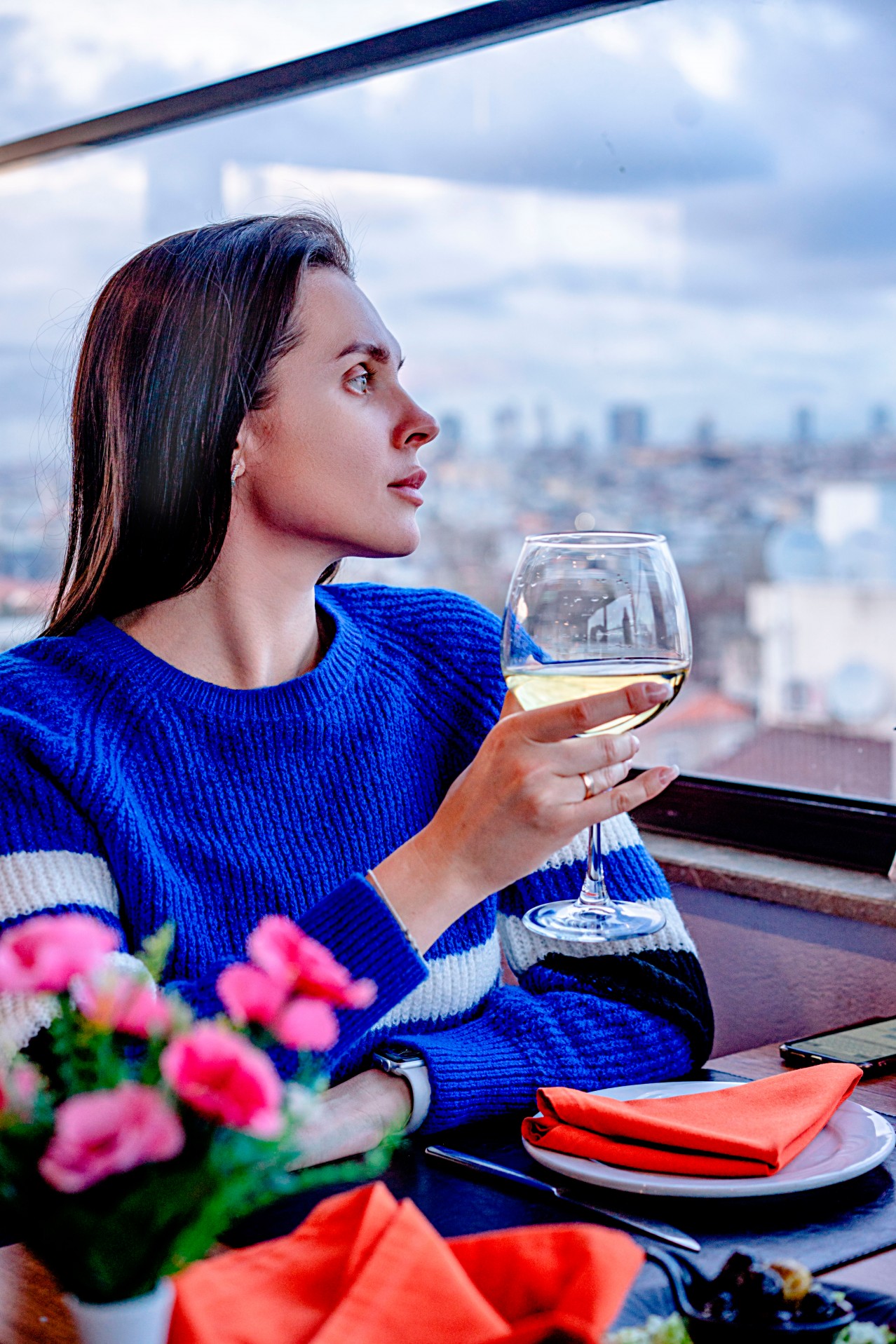 Brunette woman holding glass of wine in restaurant