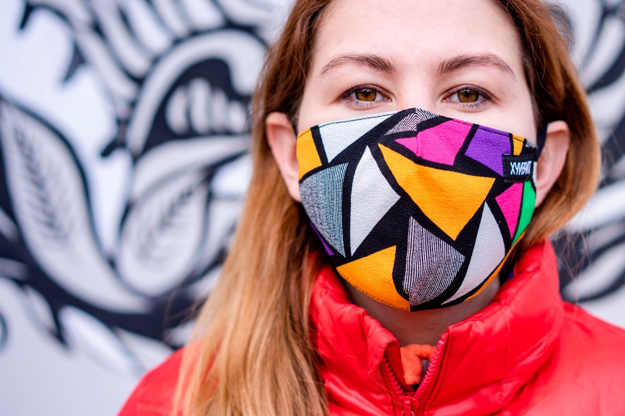 Pretty young woman wearing colorful mask