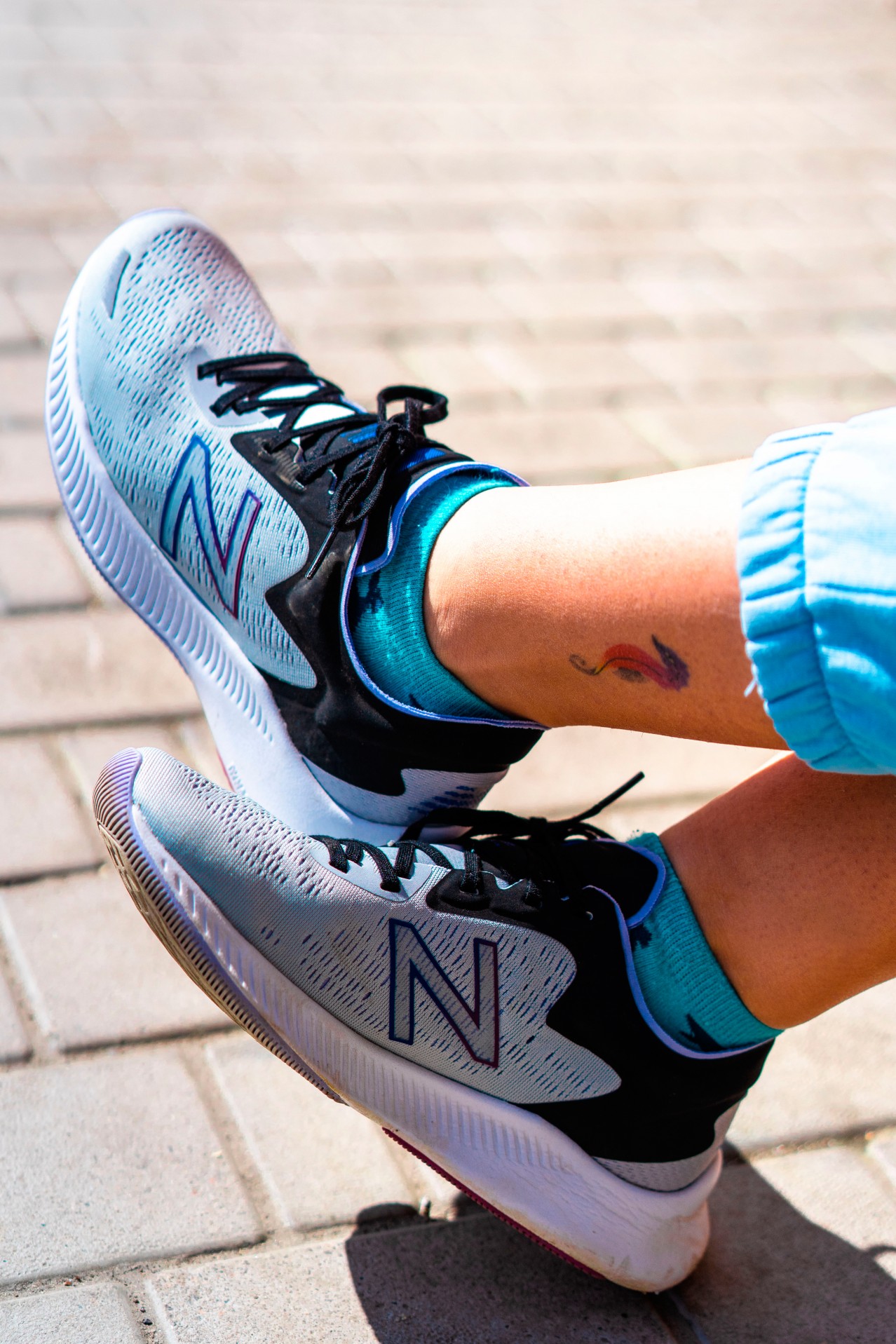 Woman in sneakers with tattoo on the ankle