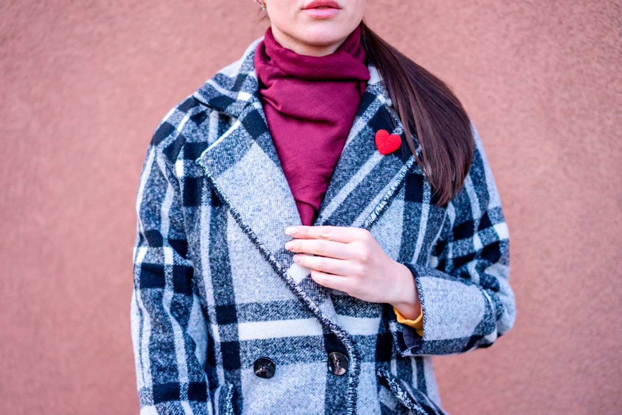 Stylish young woman wearing a checkered coat