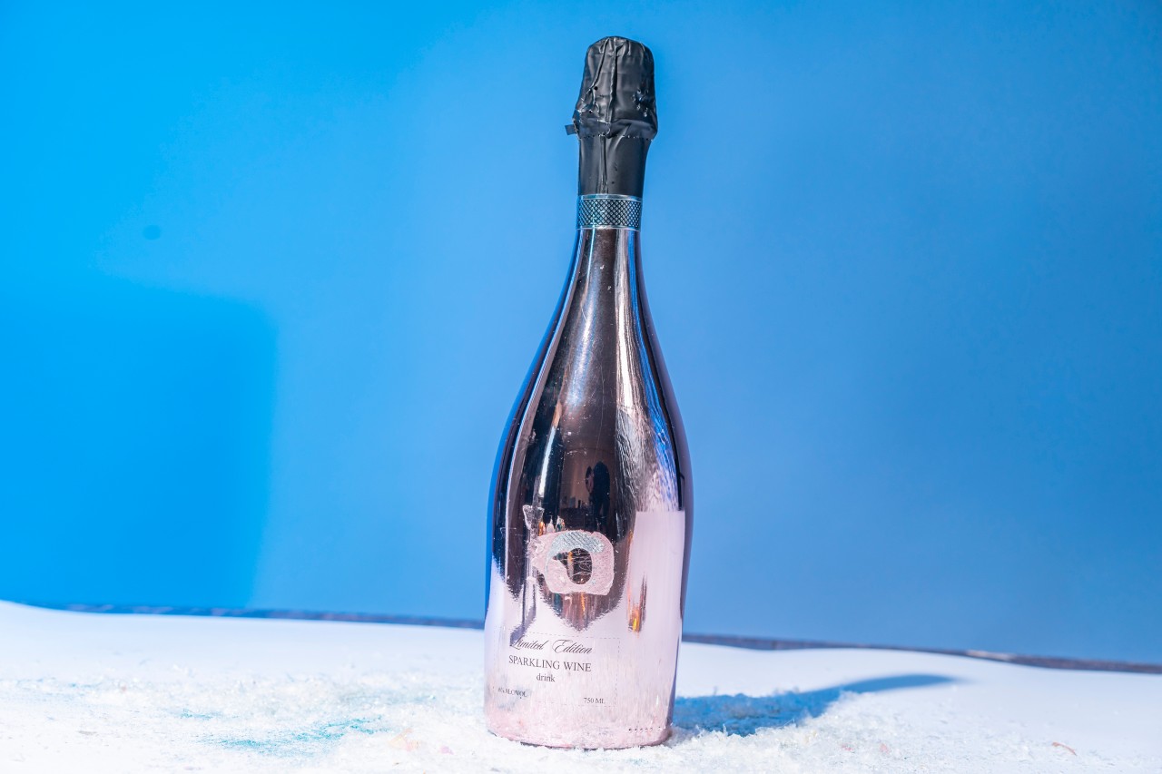 Shiny Champagne bottle on blue background