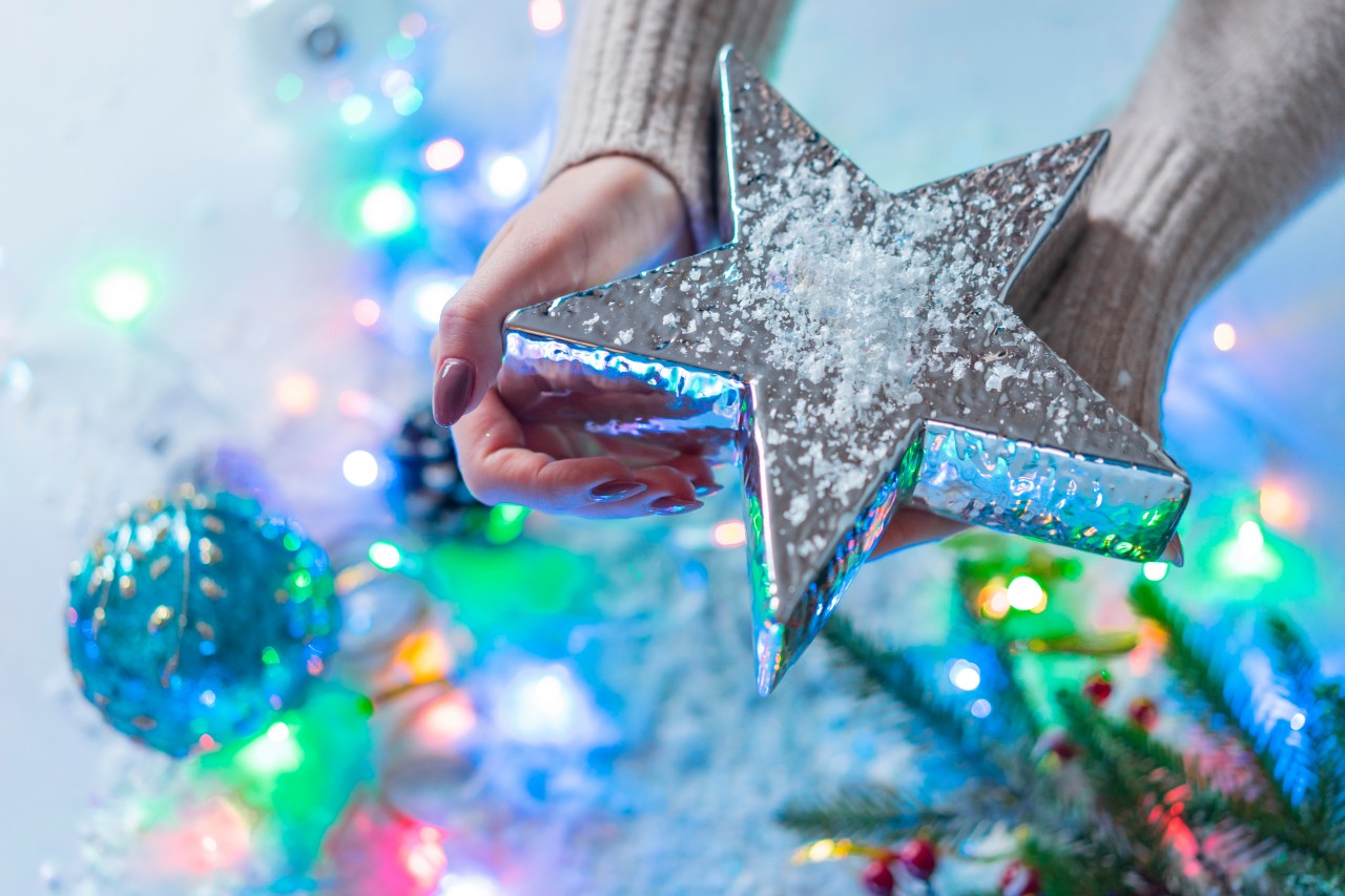 Woman holds shiny Christmas star