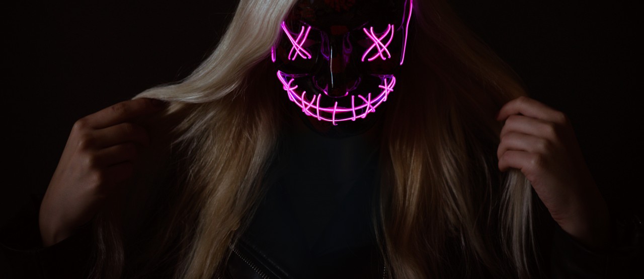 Blonde girl in scary neon mask